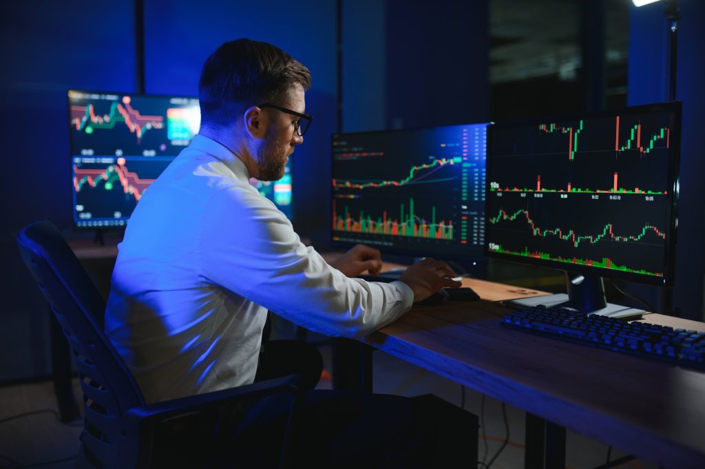 Financial Analyst. Businessman Works in Investment Bank Downtown Office at Night